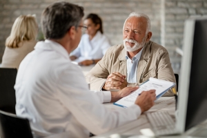 Happy senior man and his doctor going through medical insurance