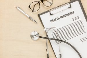 Top view health insurance form and eyeglasses with stethoscope o
